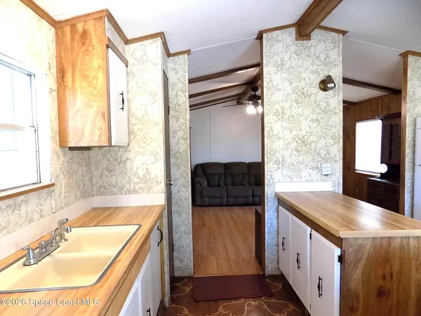 a bathroom with a granite countertop sink a mirror and shower