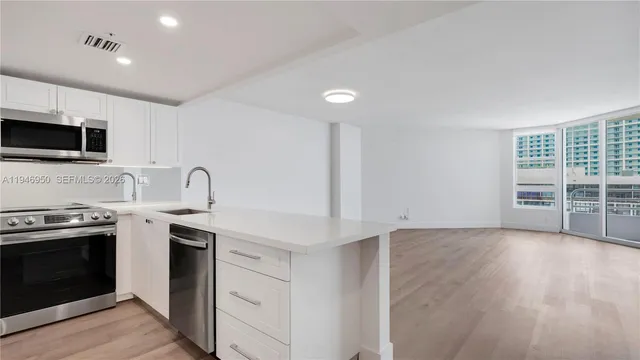 a kitchen with stainless steel appliances a stove sink and microwave