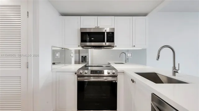 a kitchen with stainless steel appliances granite countertop a sink a stove a microwave and cabinets