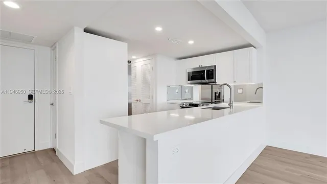 a kitchen with refrigerator and microwave