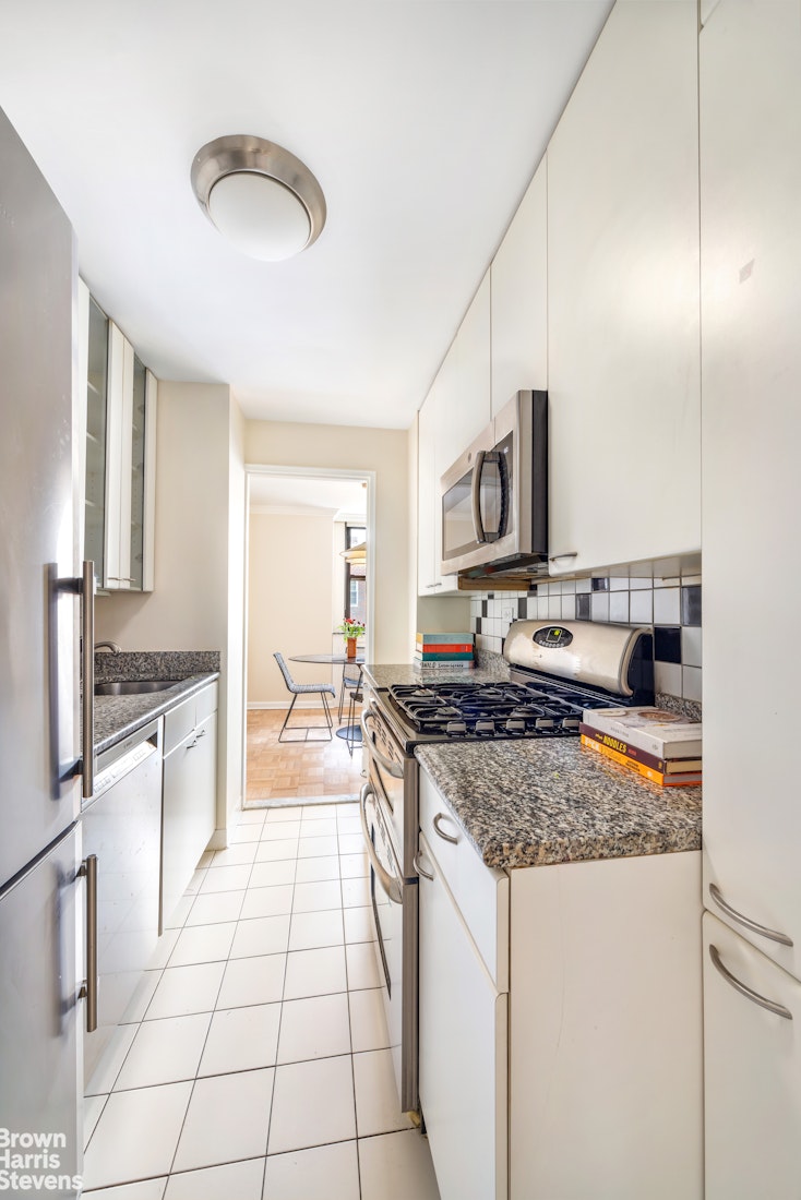 239 East 79th Street, Unit 12P Manhattan, NY 10075 - Photo 4 of 9 a kitchen with stainless steel appliances granite countertop a stove a sink and a microwave