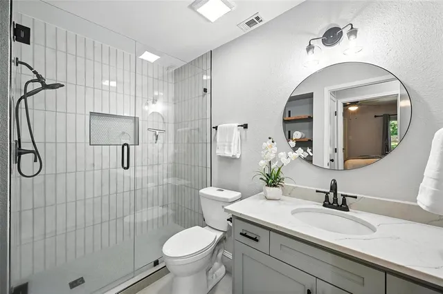 a bathroom with a sink a toilet and shower