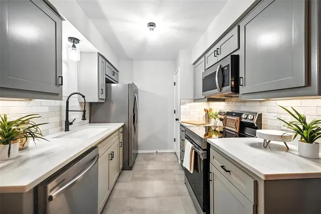 a kitchen with granite countertop a sink and stainless steel appliances