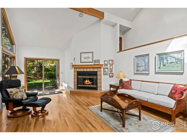 a living room with furniture a fireplace and a large window