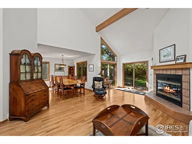 a living room with furniture a fireplace a rug and a large window