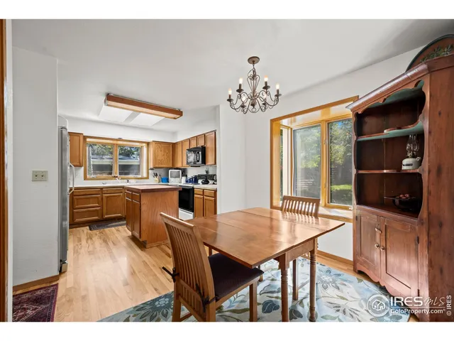 a living room with couches a dining table and chairs with wooden floor