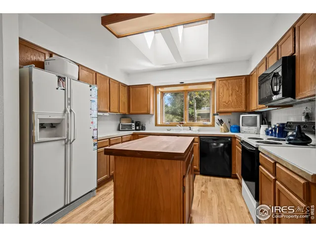 a kitchen with stainless steel appliances granite countertop a refrigerator a sink dishwasher a stove with wooden cabinets