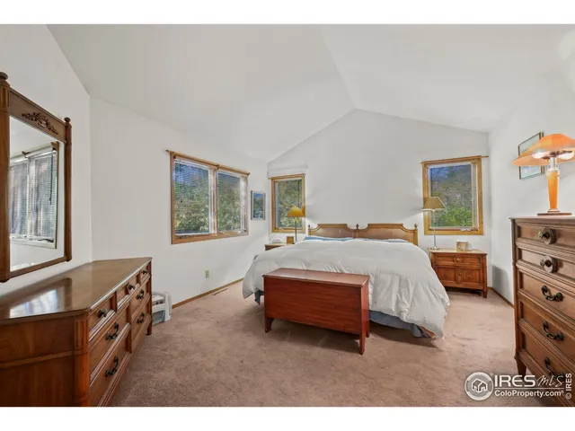 a spacious bedroom with a bed and a dresser