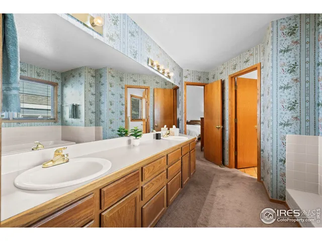 a bathroom with a sink a mirror and a bathtub next to a window