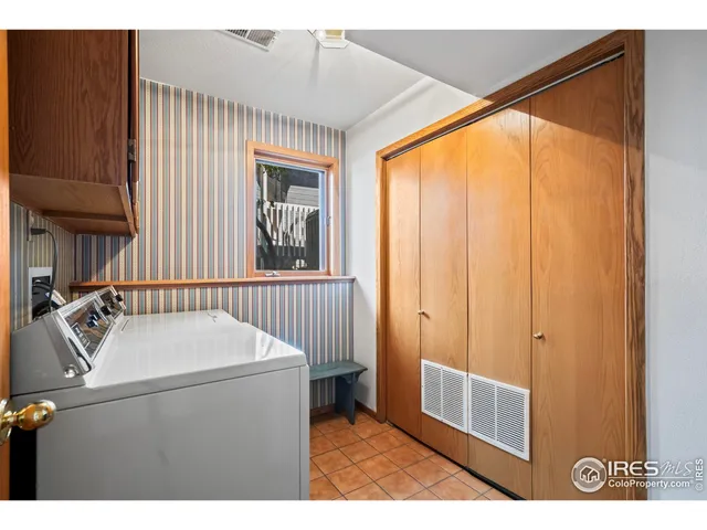 a view of a yard with plants and large trees