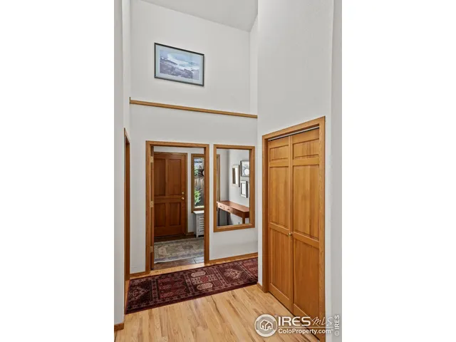 a view of a hallway with wooden floor and a bathroom