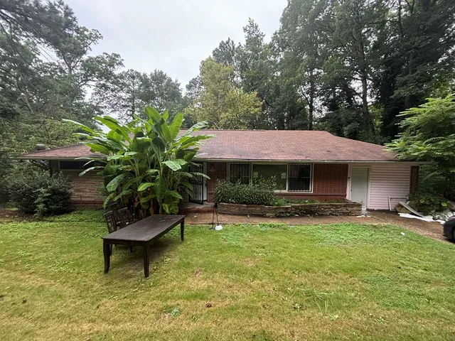 a view of a house with backyard garden and sitting area