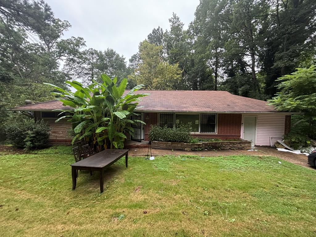 a view of a house with backyard garden and sitting area