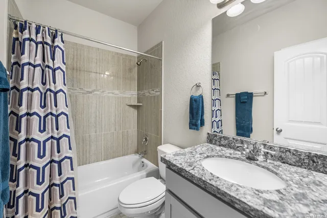 a bathroom with a granite countertop sink toilet bathtub and shower
