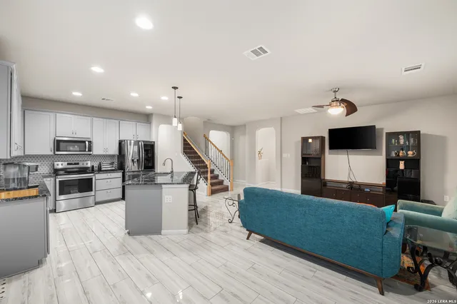 a living room with stainless steel appliances kitchen island furniture and a view of kitchen