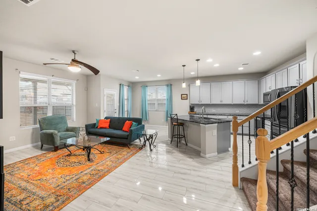a living room with furniture stairs and a wooden floor