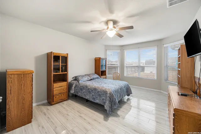 a bedroom with a bed and flat tv screen on the dresser