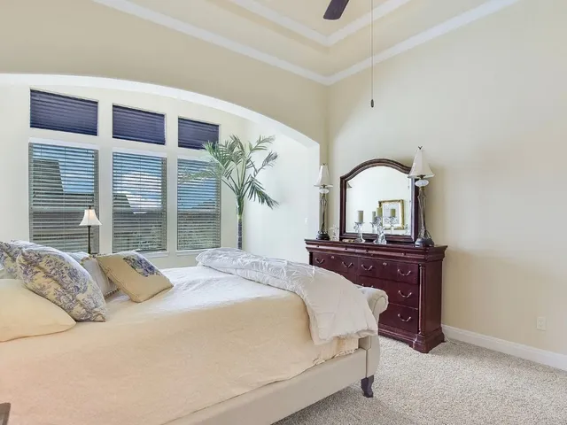 a bedroom with a bed and a large window with balcony
