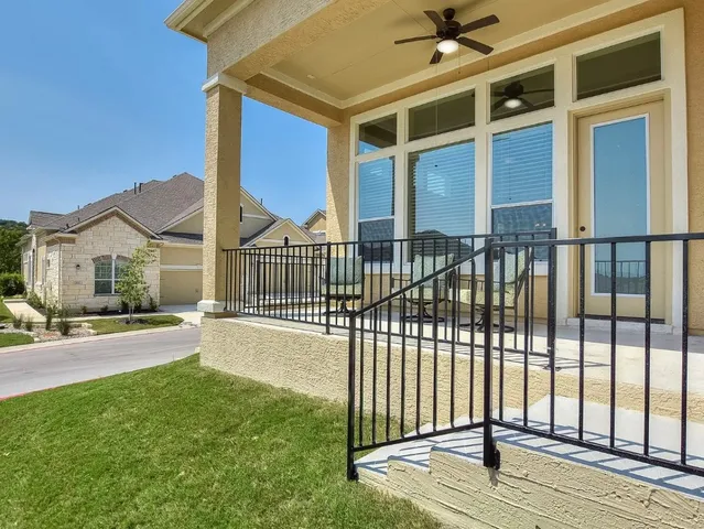 a view of a house with a floor to ceiling window and wooden fence