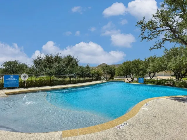 a view of a swimming pool and trees in the background