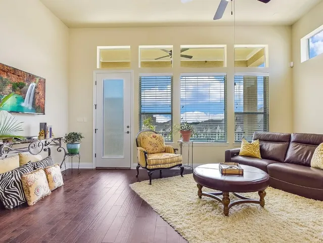 a living room with furniture wooden floor and a large window
