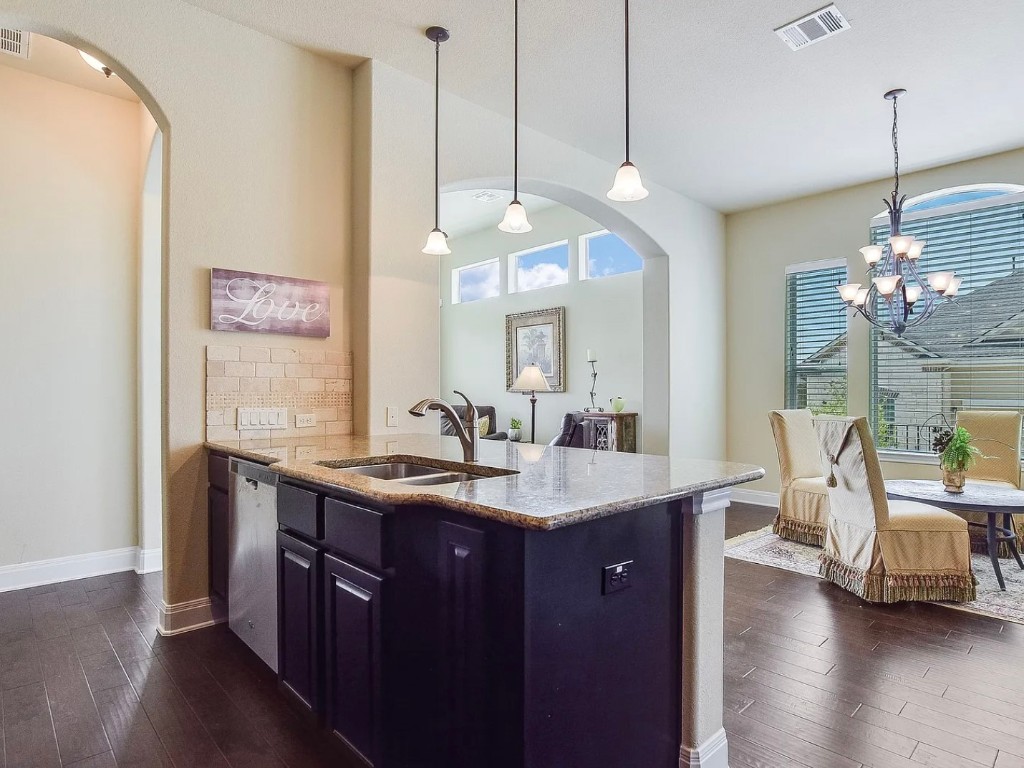 106 Evolutions Path Austin, TX 78738 - Photo 8 of 24 a view of a kitchen counter space a sink wooden floor and a chandelier