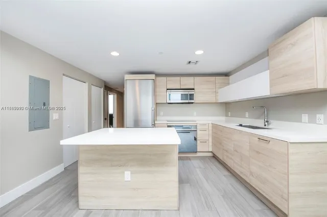 a kitchen with stainless steel appliances a sink dishwasher stove refrigerator and microwave