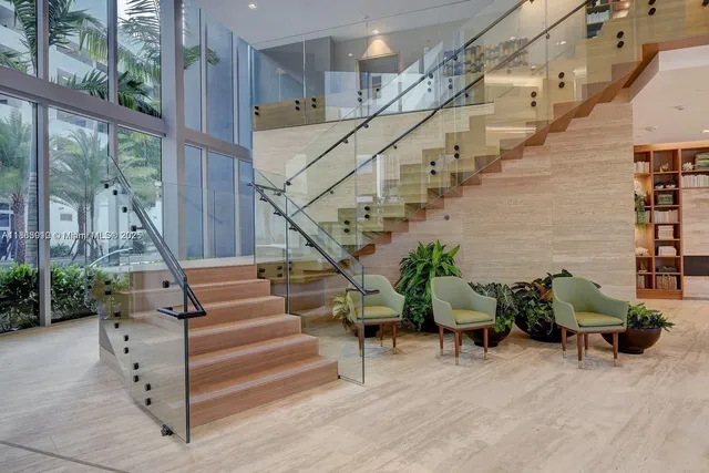 a living room with furniture floor to ceiling window and wooden floor
