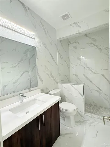 a bathroom with a sink a toilet and a mirror