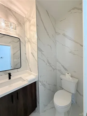 a bathroom with a sink vanity mirror and toilet