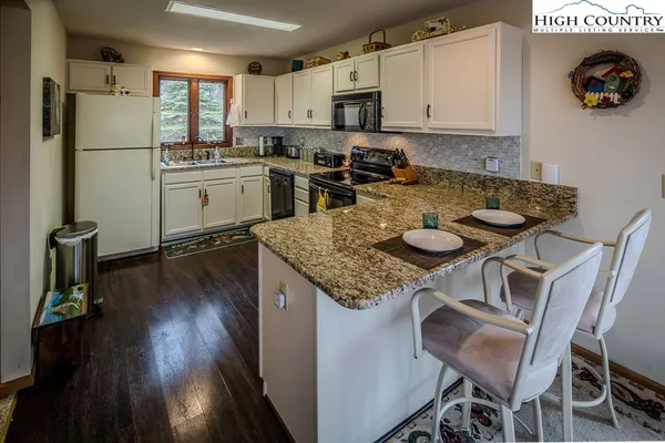 a kitchen with kitchen island a stove a table and chairs in it