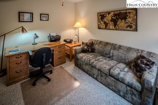 a living room with furniture and a lamp on dresser