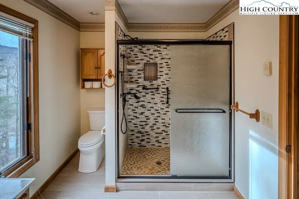 a bathroom with a toilet and a shower