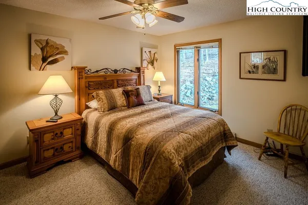 a bed sitting in a bedroom next to a window with a bookshelf