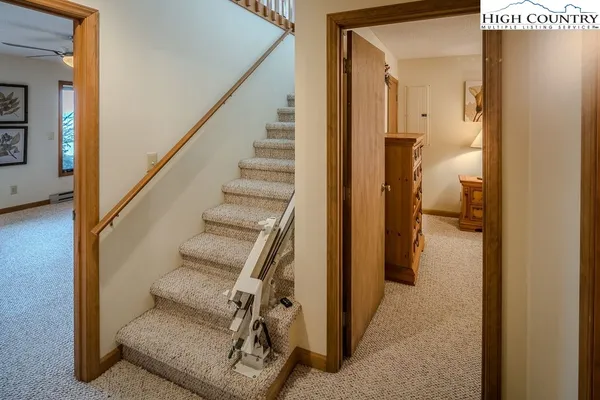 a view of a hallway with wooden floor and staircase