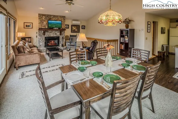 a view of a dining room with furniture a chandelier and wooden floor