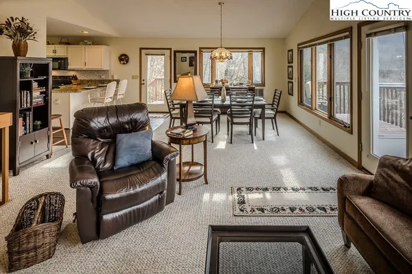 a living room with furniture a rug and a floor to ceiling window