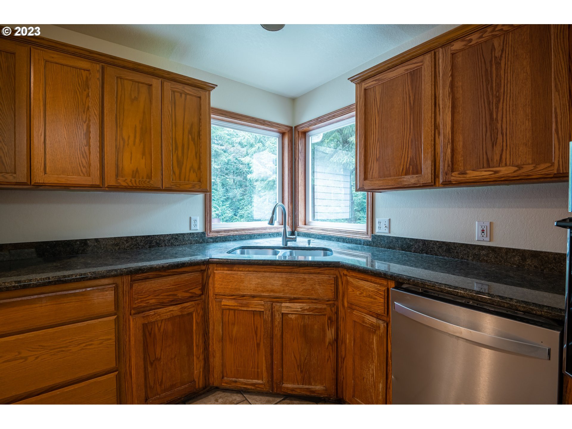 87763 Two Mile Lane Bandon, OR 97411 - Photo 18 of 41 a kitchen with granite countertop wooden cabinets a sink and dishwasher
