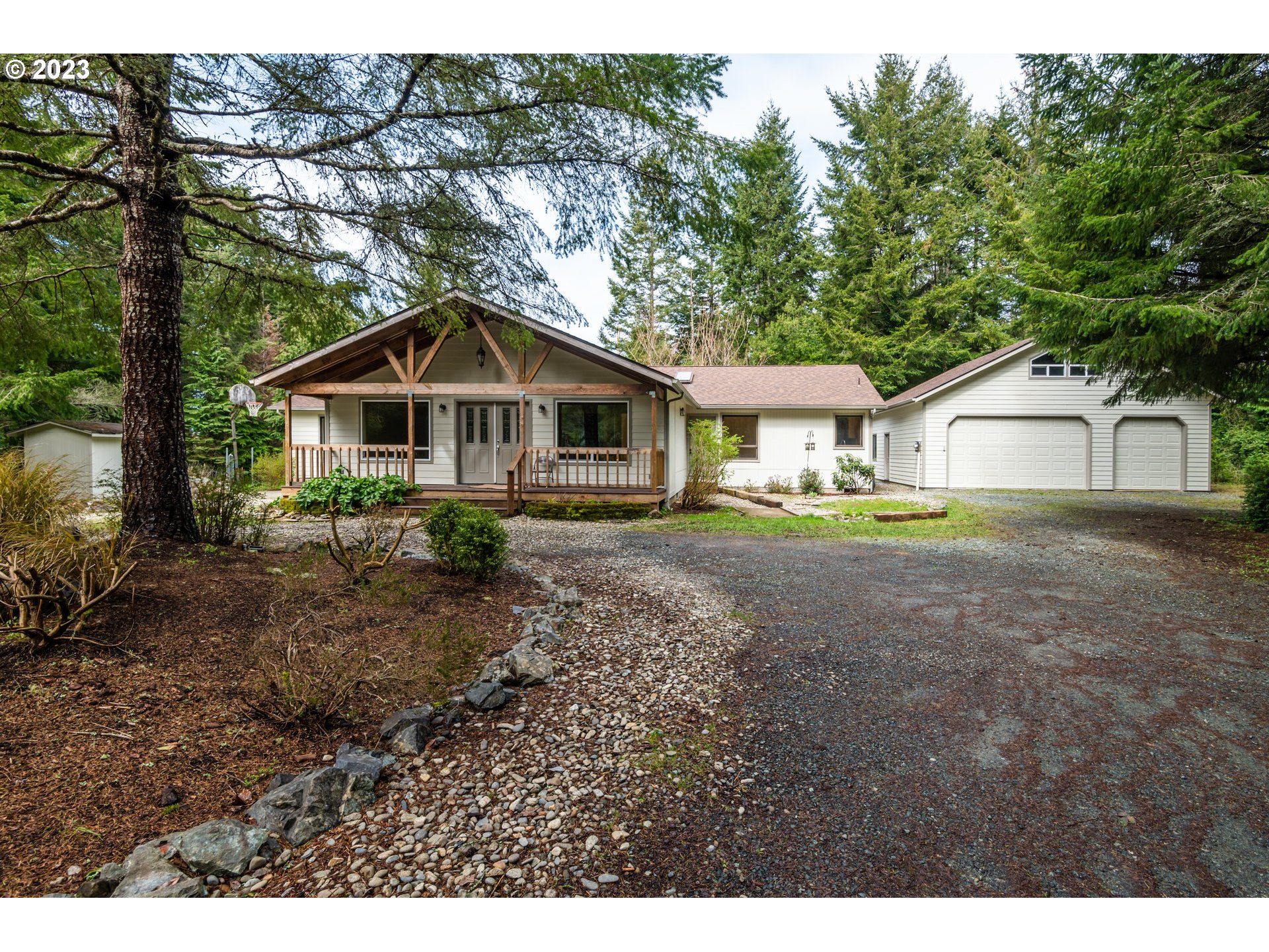 87763 Two Mile Lane Bandon, OR 97411 - Photo 2 of 41 a front view of a house with a garden