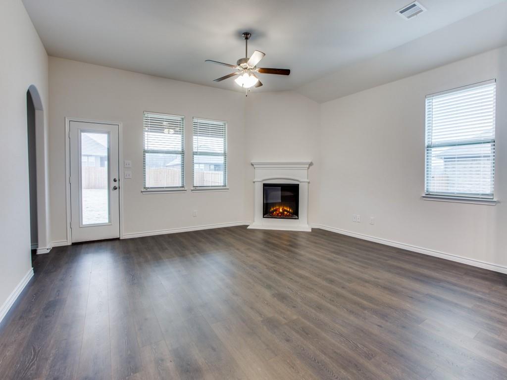 123 Lakeview Circle Pilot Point, TX 76258 - Photo 11 of 39 an empty room with wooden floor fireplace and windows