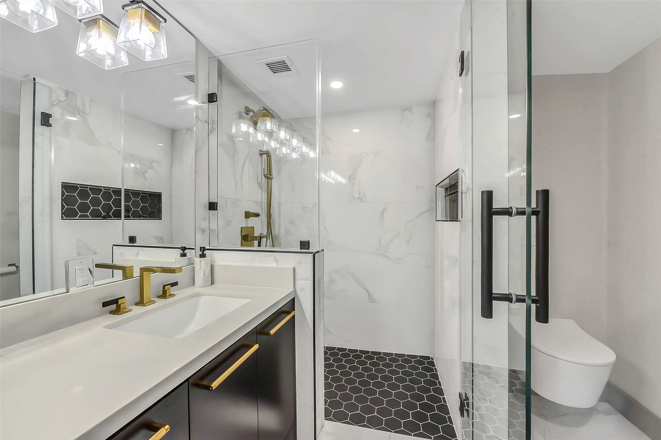 1111 Caroline Street, Unit 2903 Houston, TX 77010 - Photo 12 of 27 A closer look at the primary bath highlights the seamless glass-enclosed walk-in shower and premium tiling, and a bidet toilet reflecting the high-end craftsmanship found throughout the unit.