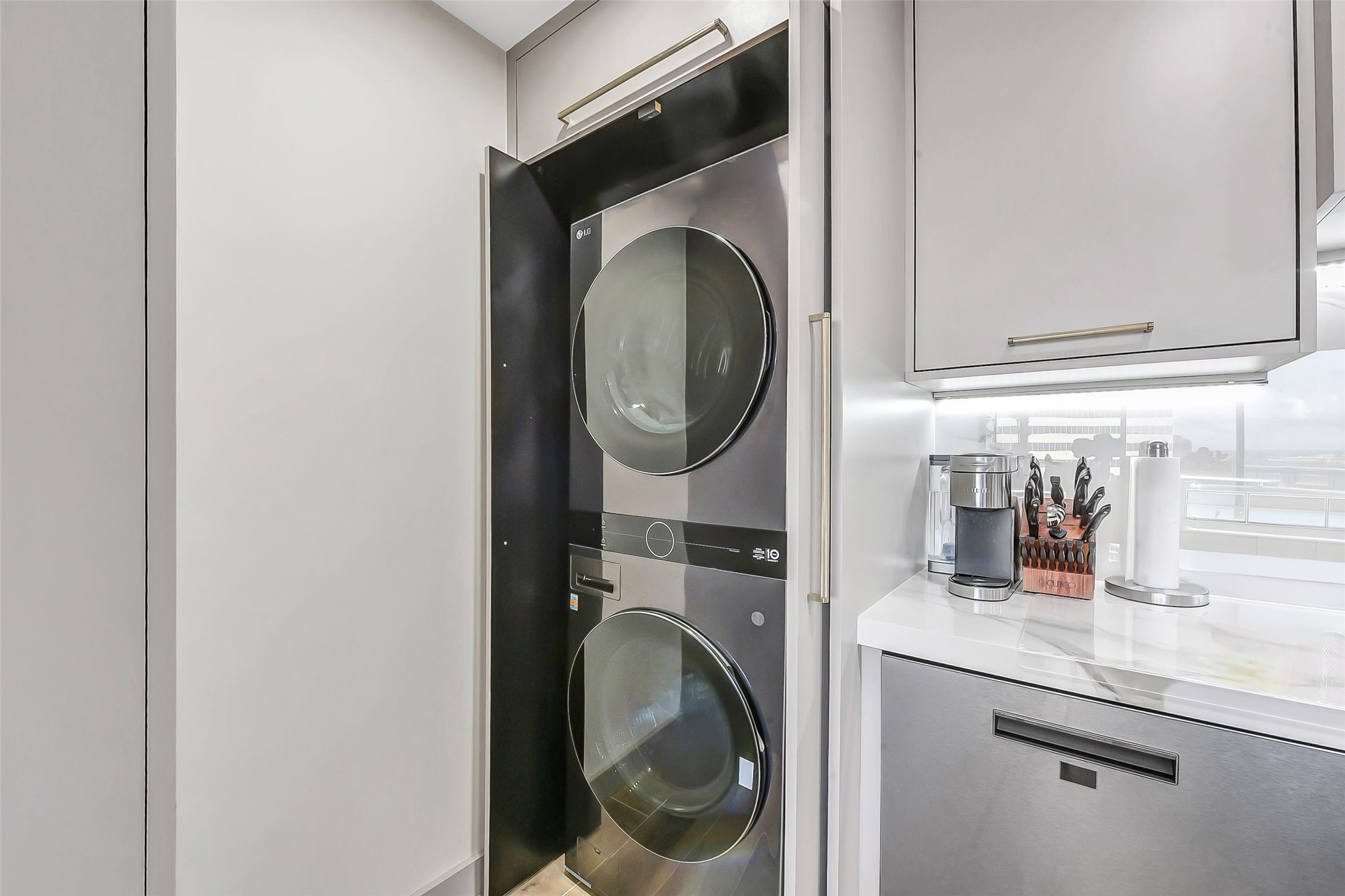 1111 Caroline Street, Unit 2903 Houston, TX 77010 - Photo 15 of 27 Discreetly integrated into the kitchen's prep area, the laundry nook features a high-end, full-sized stacked washer and dryer in a modern finish.