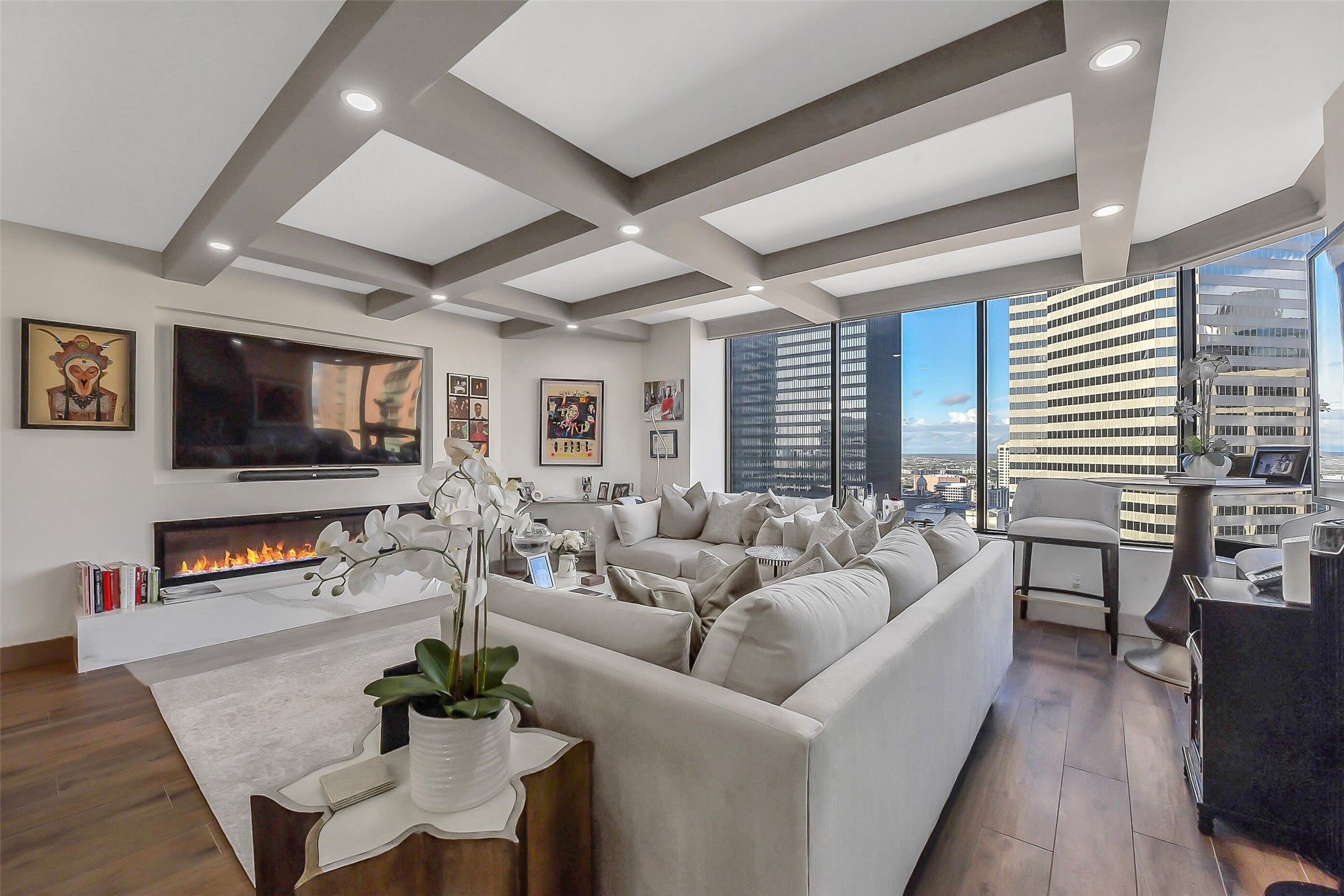 1111 Caroline Street, Unit 2903 Houston, TX 77010 - Photo 4 of 27 This living area view highlights large windows and a sleek modern fireplace. The clever layout includes an additional seating area behind the sofa, creating a perfect reading nook or secondary lounge to enjoy spectacular Downtown Houston views.