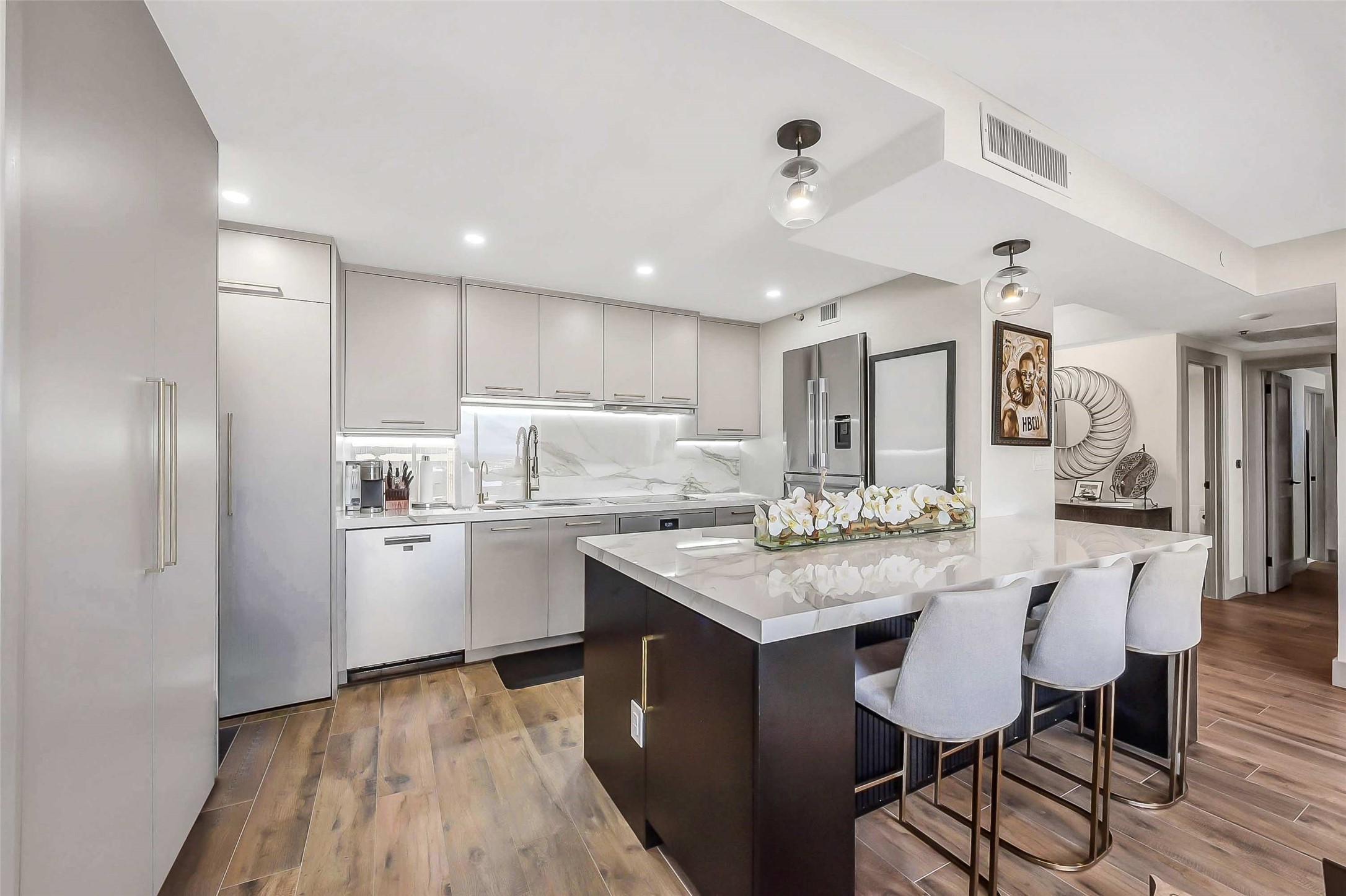 1111 Caroline Street, Unit 2903 Houston, TX 77010 - Photo 5 of 27 The gourmet kitchen is a chef’s dream, featuring premium stainless steel appliances, sleek modern cabinetry, and beautiful countertops. The oversized island with a breakfast bar provides the perfect transition into the living area.