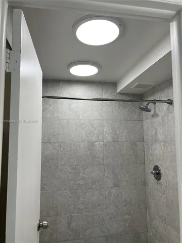 a bathroom with a shower and a mirror