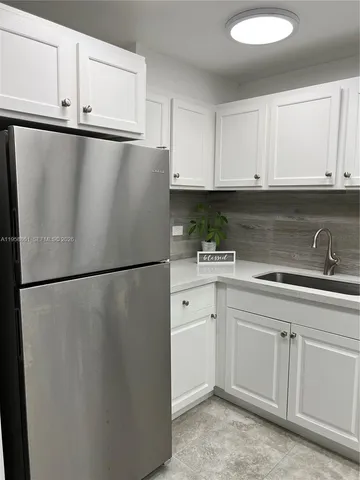 a white refrigerator freezer sitting inside of a kitchen