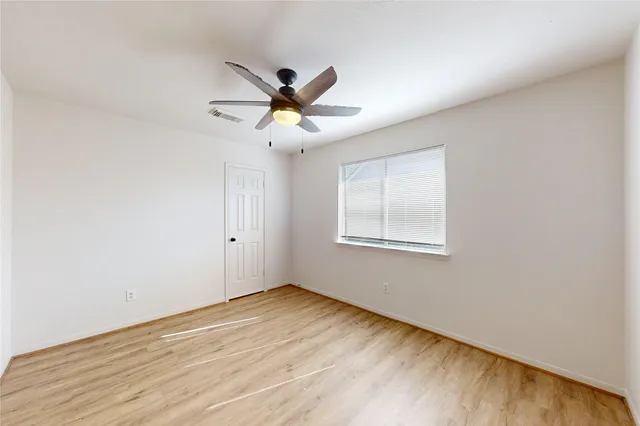 a view of a big room with wooden floor and windows