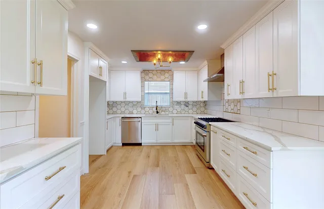a kitchen with granite countertop white cabinets and white appliances