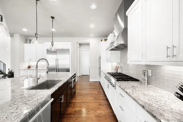 a kitchen with granite countertop kitchen island a sink stainless steel appliances and cabinets