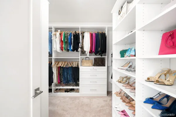 a view of walk in closet with clothes and shoes
